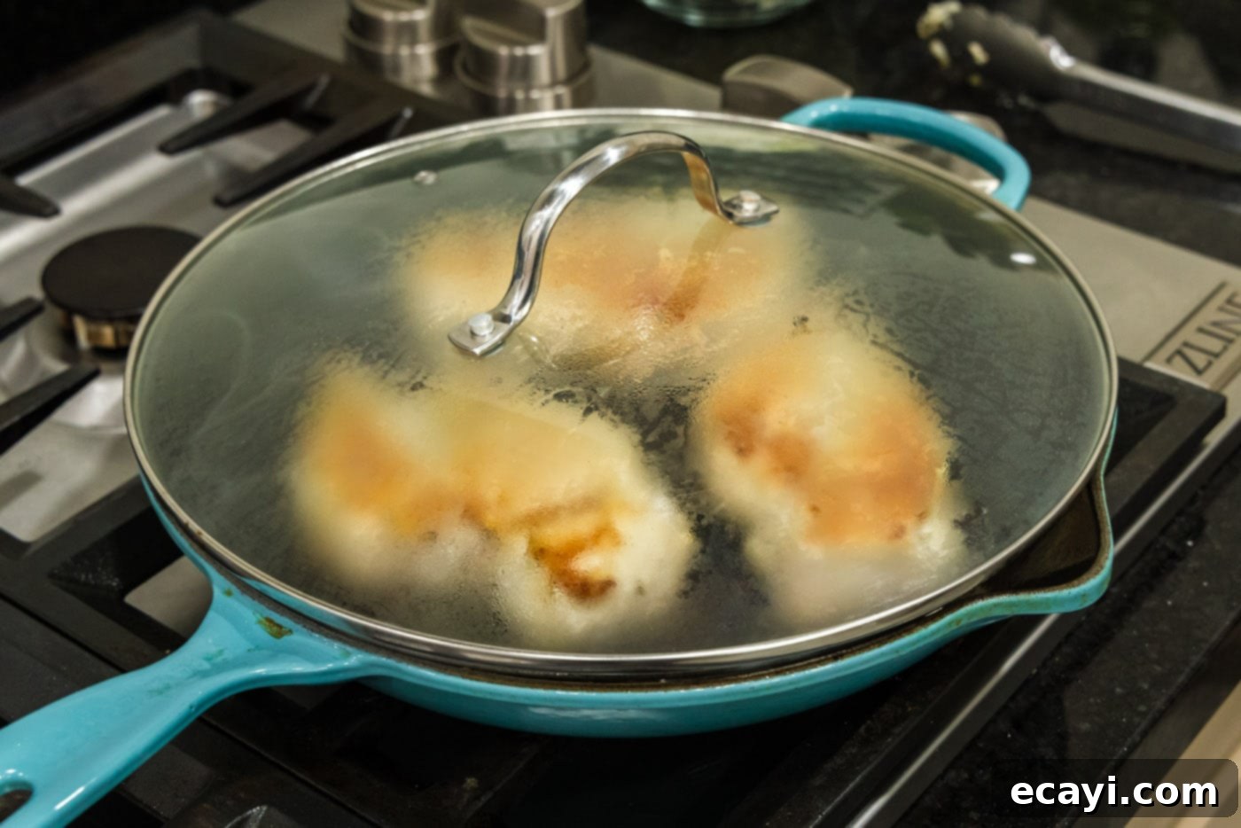Savory Onion-Thyme Chicken 11 lid on skillet over chicken breasts
