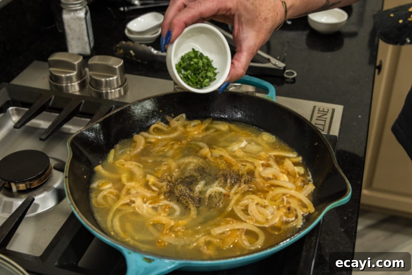 Savory Onion-Thyme Chicken 15 adding fresh thyme leaves to skillet with onion sauce