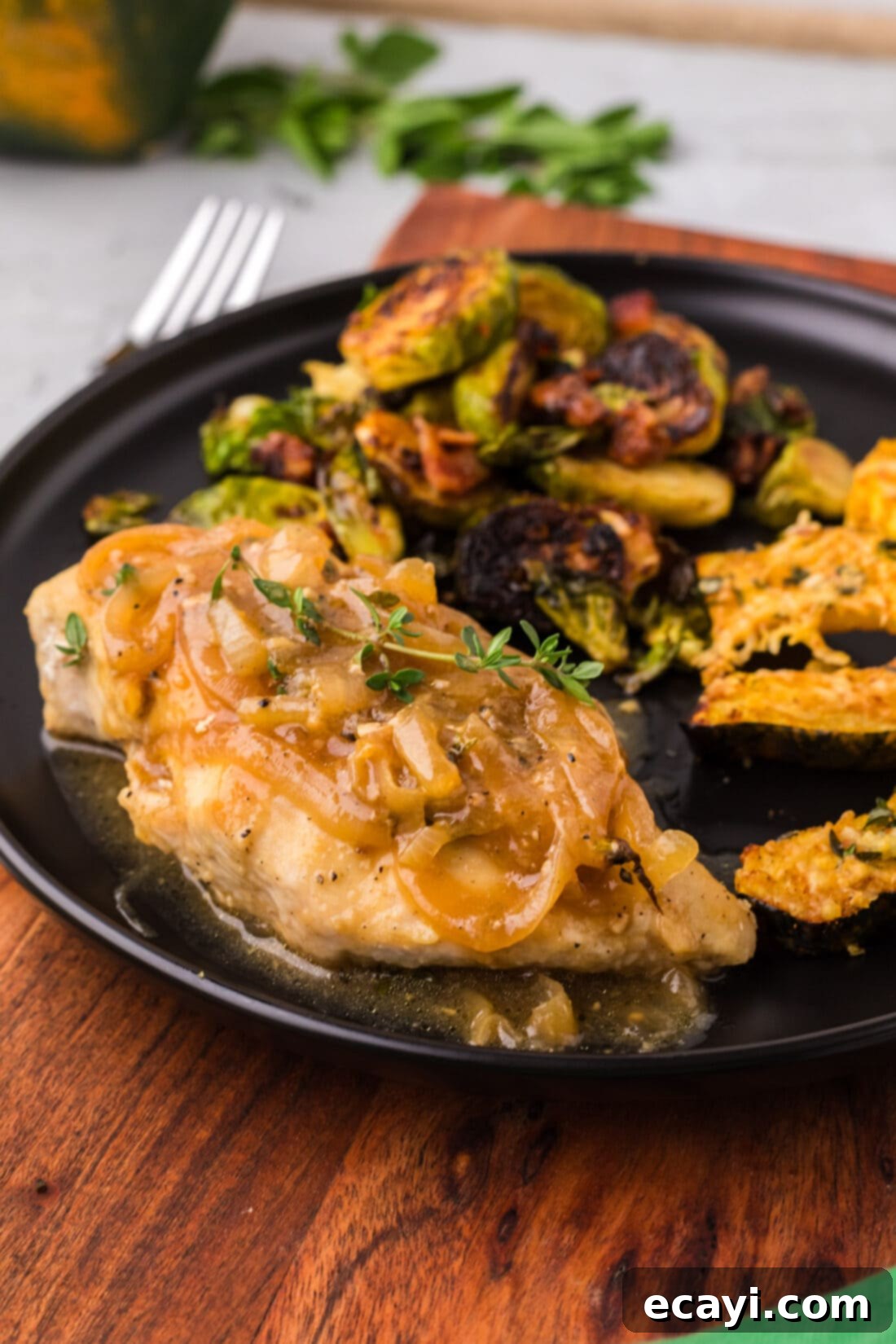 Savory Onion-Thyme Chicken 18 Chicken with Onion Thyme Sauce on a plate with Brussels sprouts and acorn squash