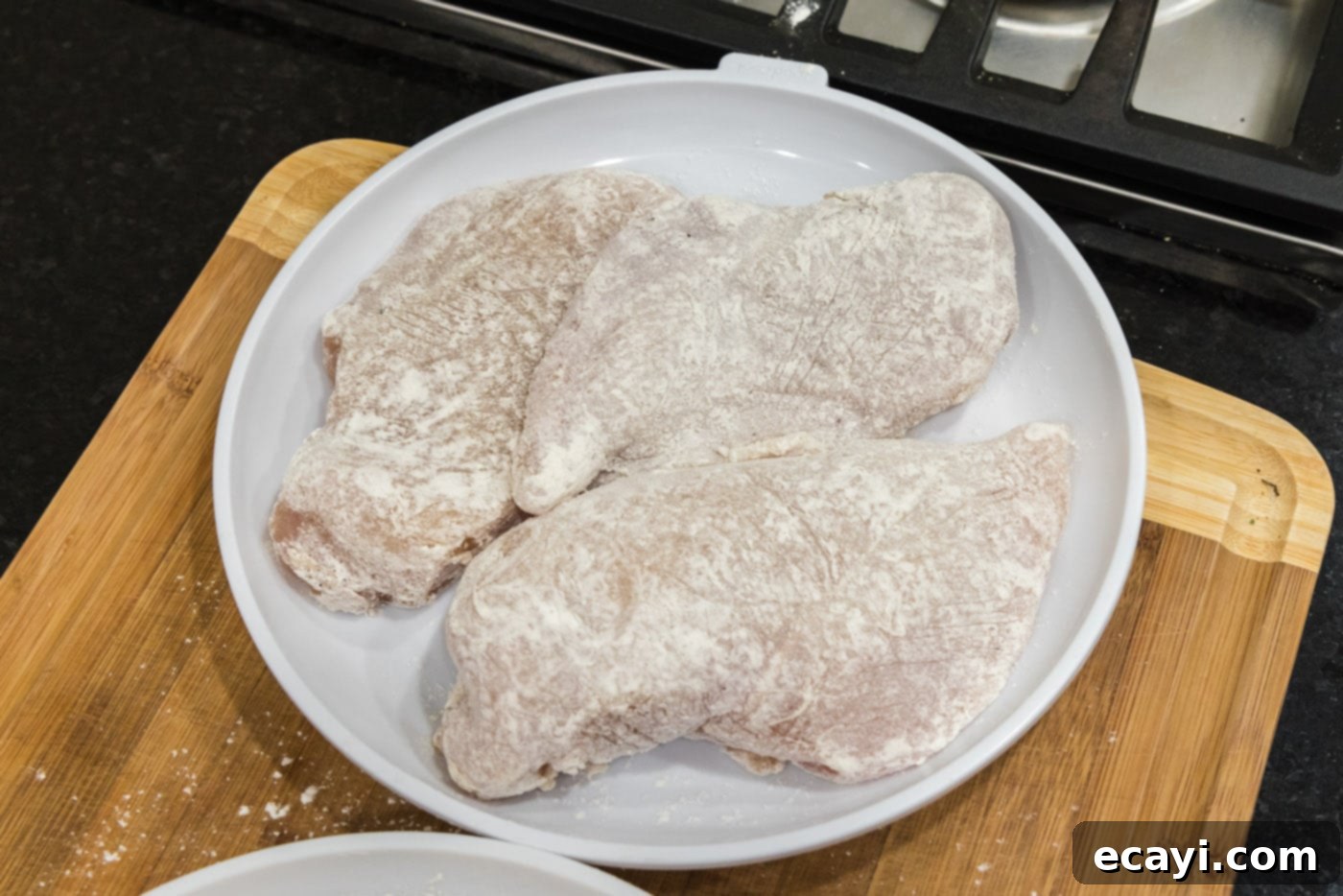 Savory Onion-Thyme Chicken 8 flour coated chicken breasts on a plate