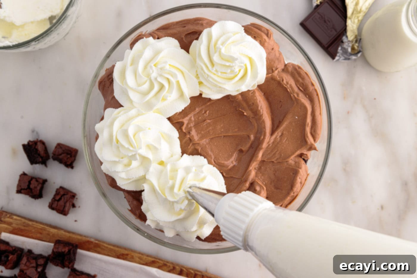 Decadent Brownie Trifle 13 Artistically piping whipped cream in swirls on top of the layered brownie trifle for a beautiful finish.