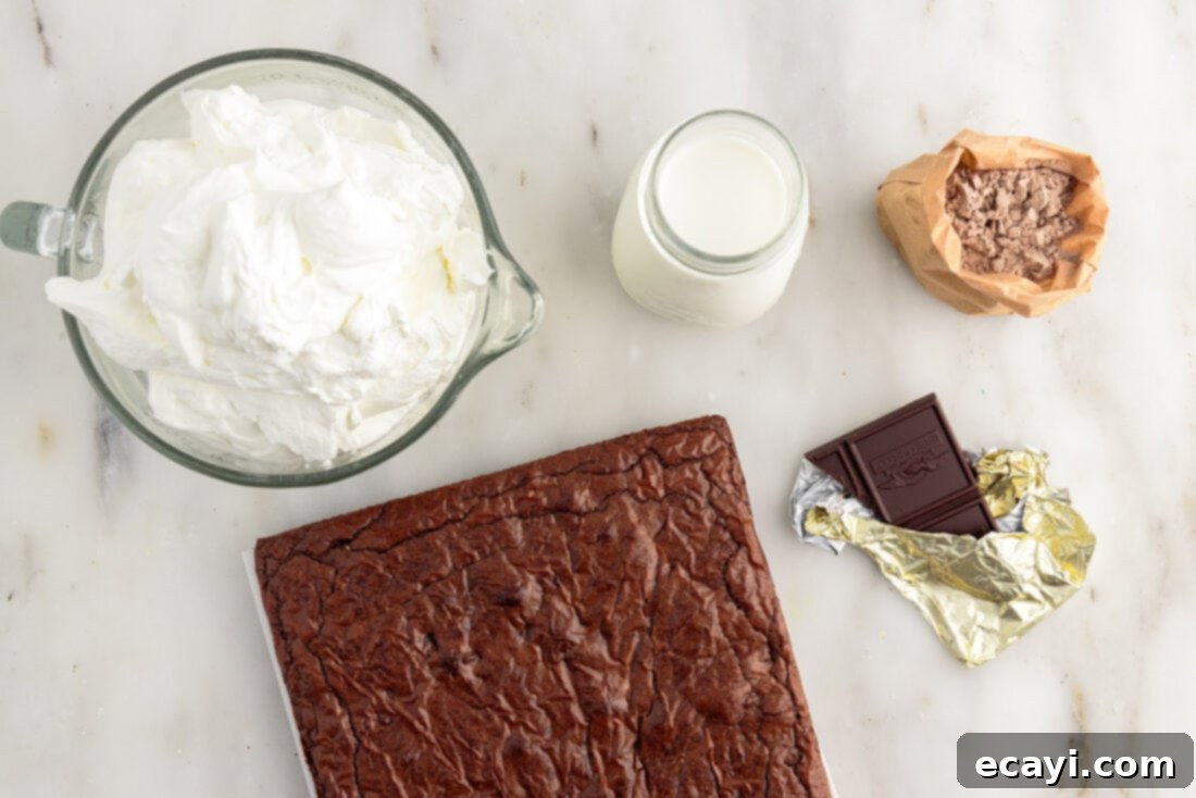 Decadent Brownie Trifle 4 A flat lay of ingredients for Brownie Trifle, including brownie mix boxes, milk, instant pudding, heavy cream, and a chocolate bar for garnish.
