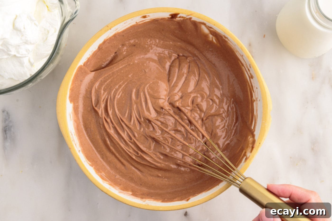 Decadent Brownie Trifle 9 Gently whisking the whipped cream into the chocolate pudding, creating a light and airy consistency.
