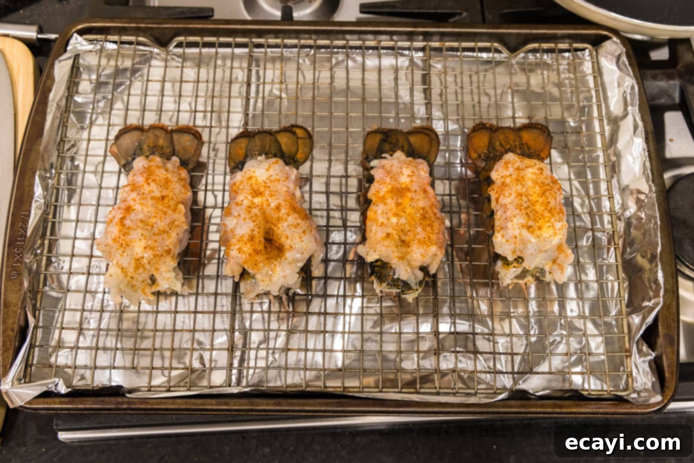 Golden Baked Lobster 11 Old bay seasoned crowned lobster tails on a baking sheet