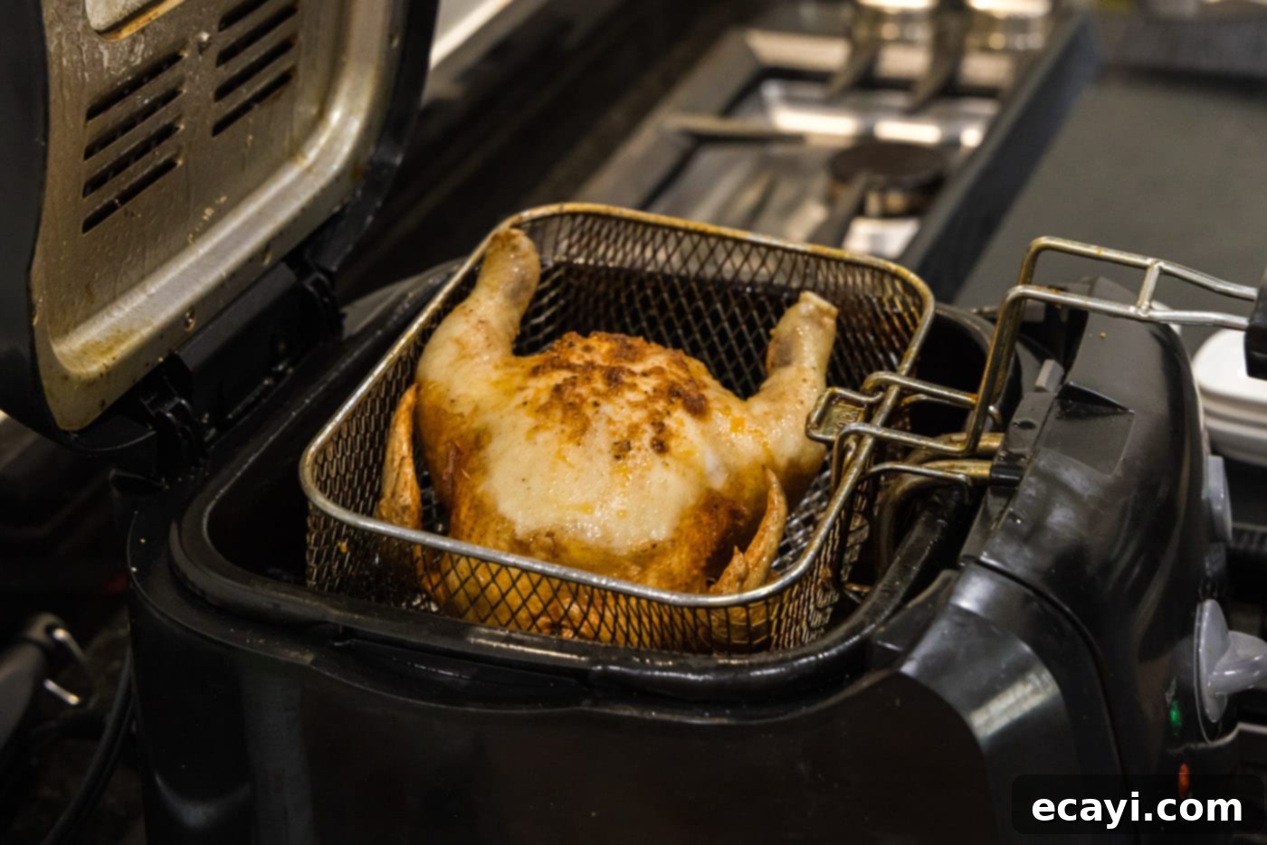Crispy Golden Cornish Hens 11 lifting cornish hen from deep fryer basket to check and flip