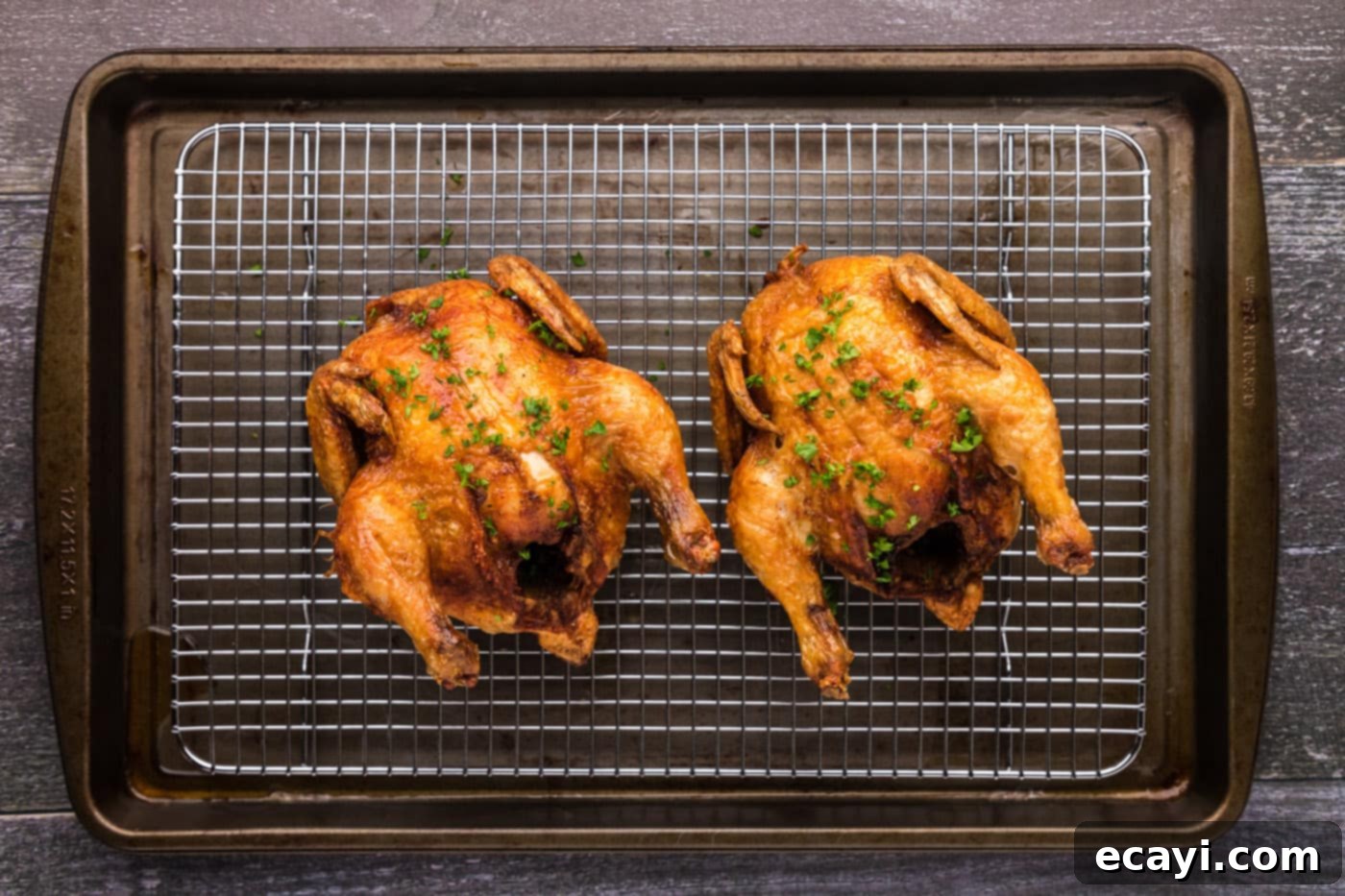 Crispy Golden Cornish Hens 13 golden skinned deep fried cornish hens on a wire cooling rack to drain