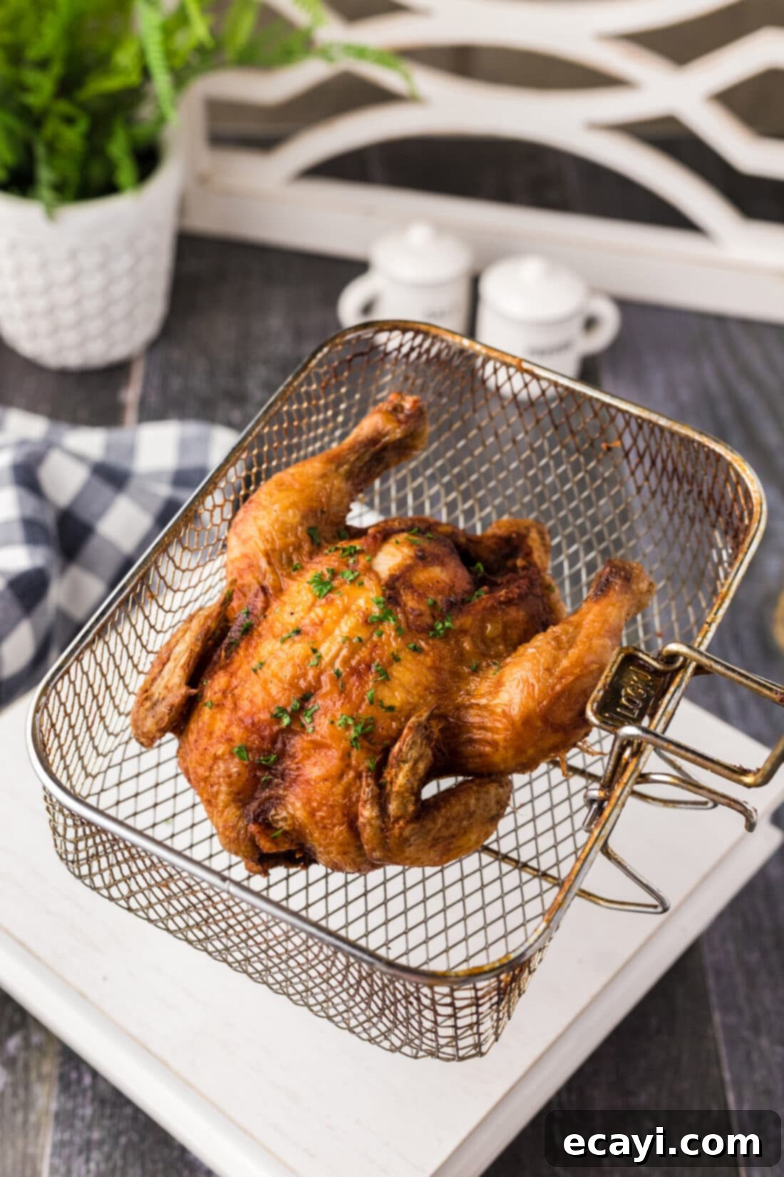 Crispy Golden Cornish Hens 3 Deep Fried Cornish Hen being lowered into a deep fryer basket, illustrating the frying process