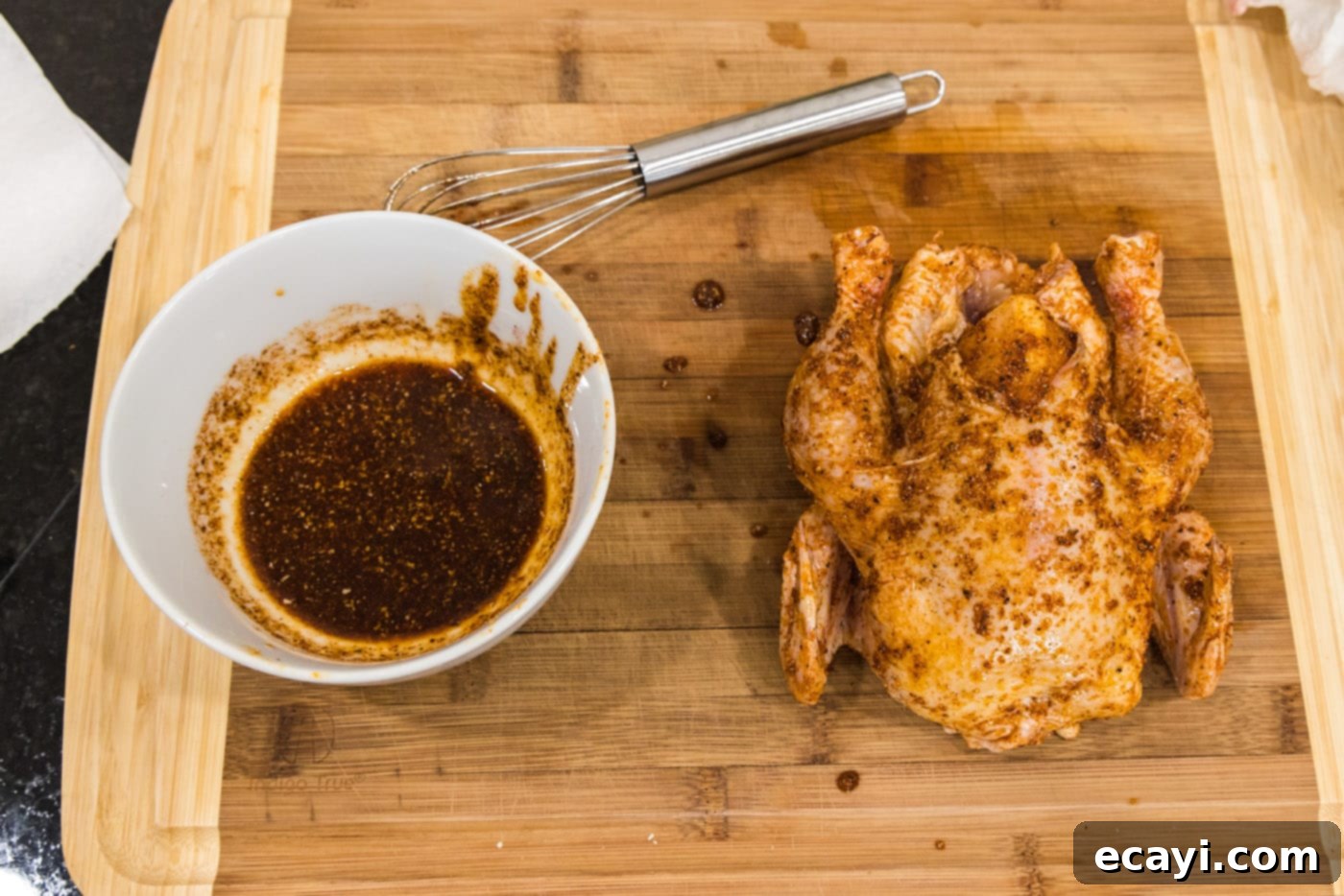 Crispy Golden Cornish Hens 8 adding wet rub to cornish hen on a cutting board, ensuring even coating