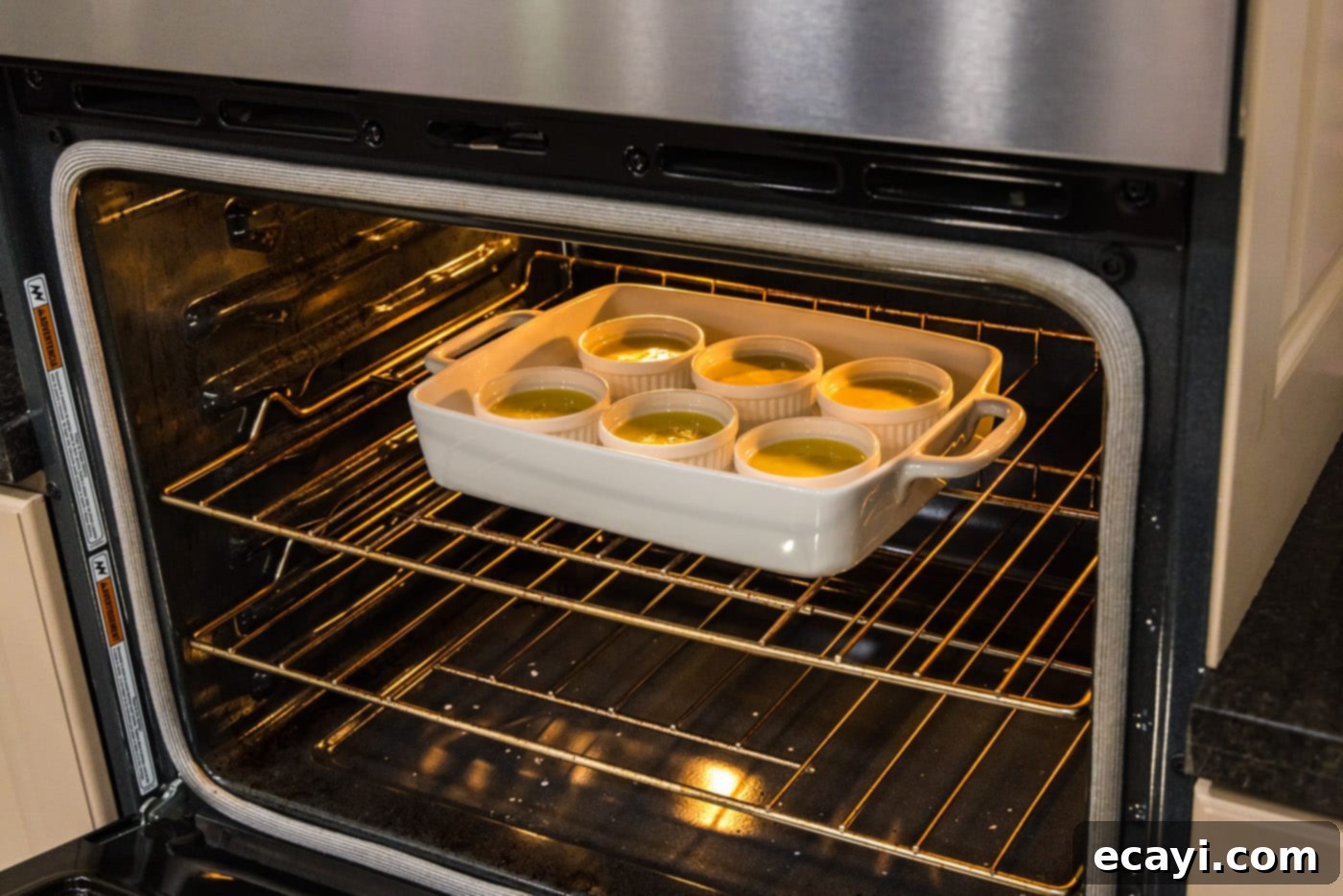Creme Brulee 17 custard in ramekins placed in the oven in a baking dish