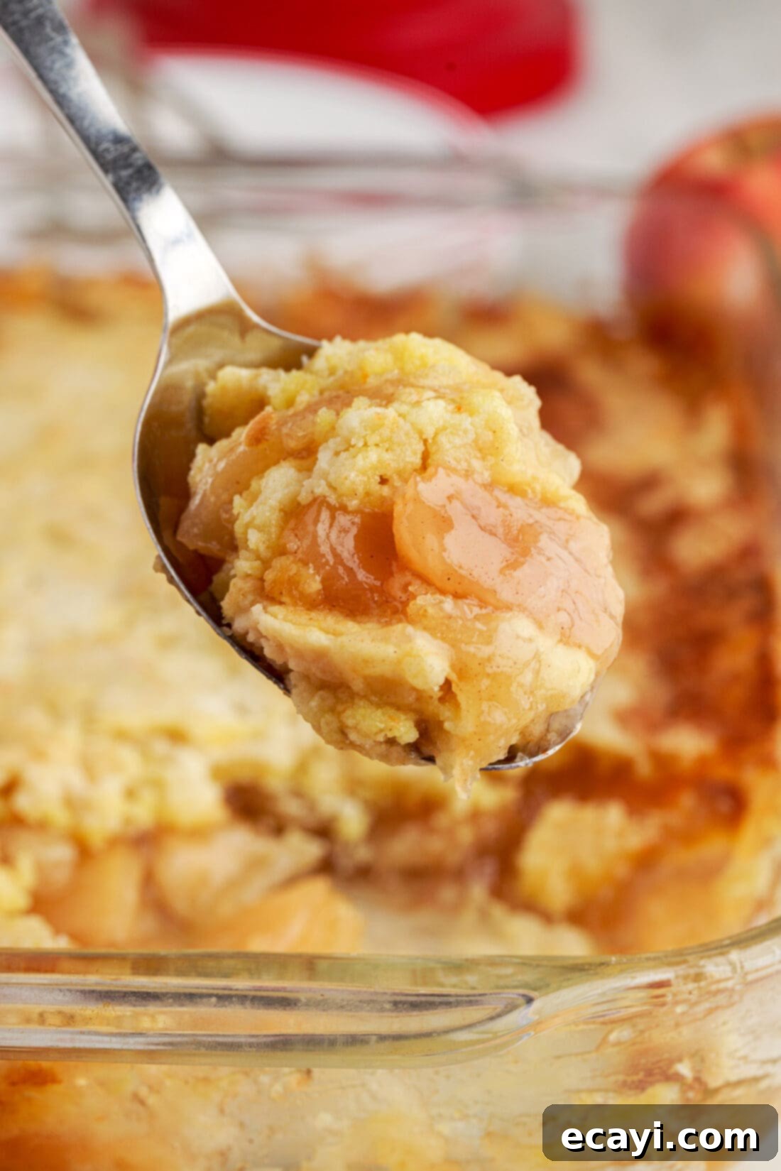 Golden Apple Streusel Bake 2 Close up photo of a spoonful of Apple Dump Cake, showcasing the tender cake topping and warm apple filling beneath.
