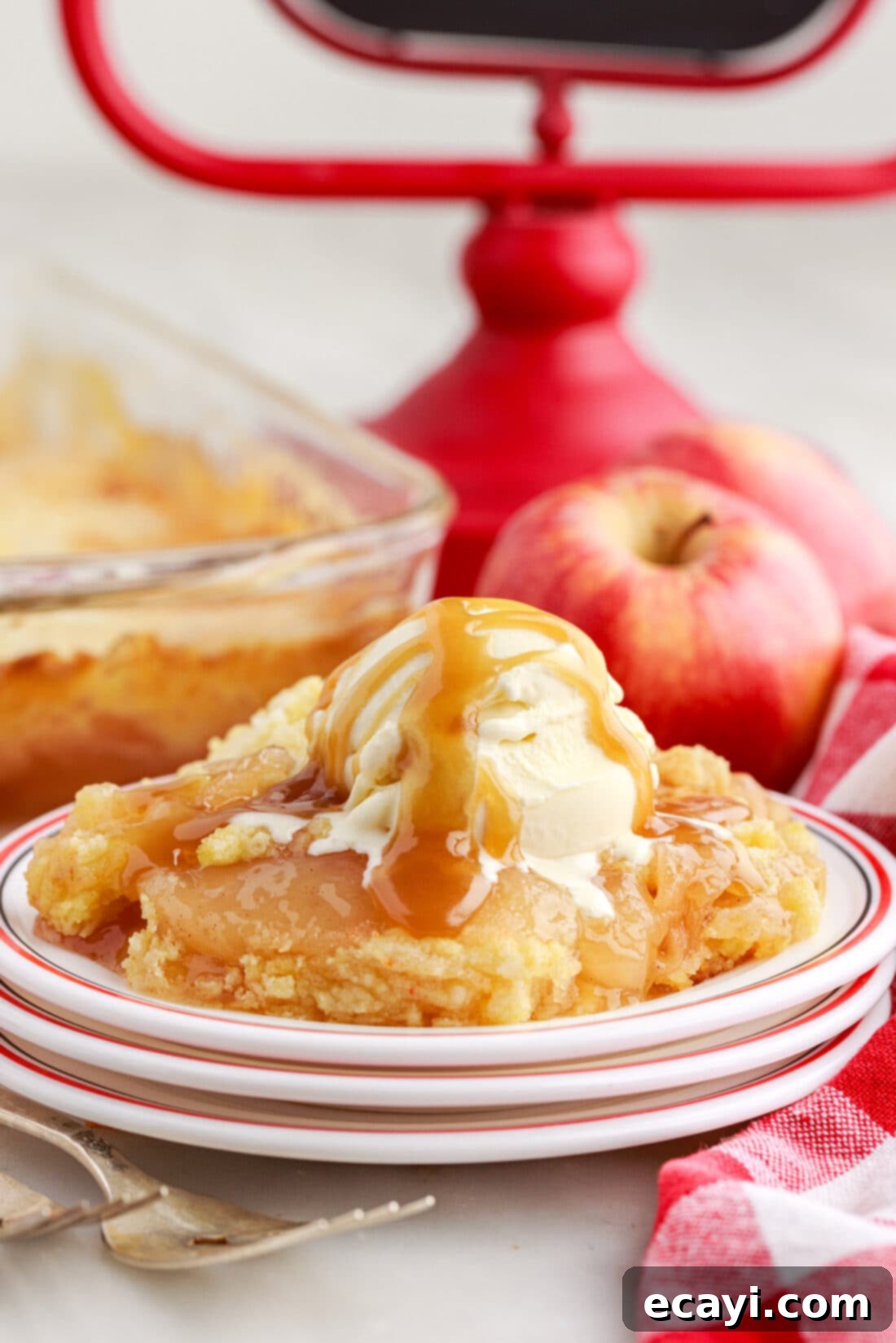 Golden Apple Streusel Bake 3 Apple Dump Cake on a plate topped with vanilla ice cream and caramel drizzle, ready to be enjoyed.