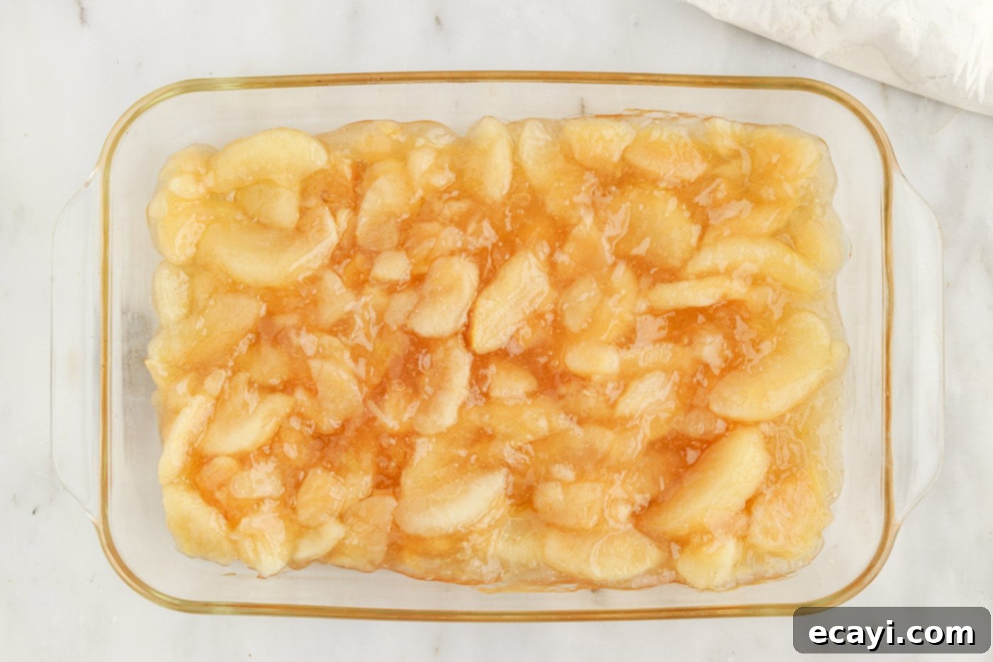 Golden Apple Streusel Bake 5 apple pie filling evenly spread in a glass baking dish