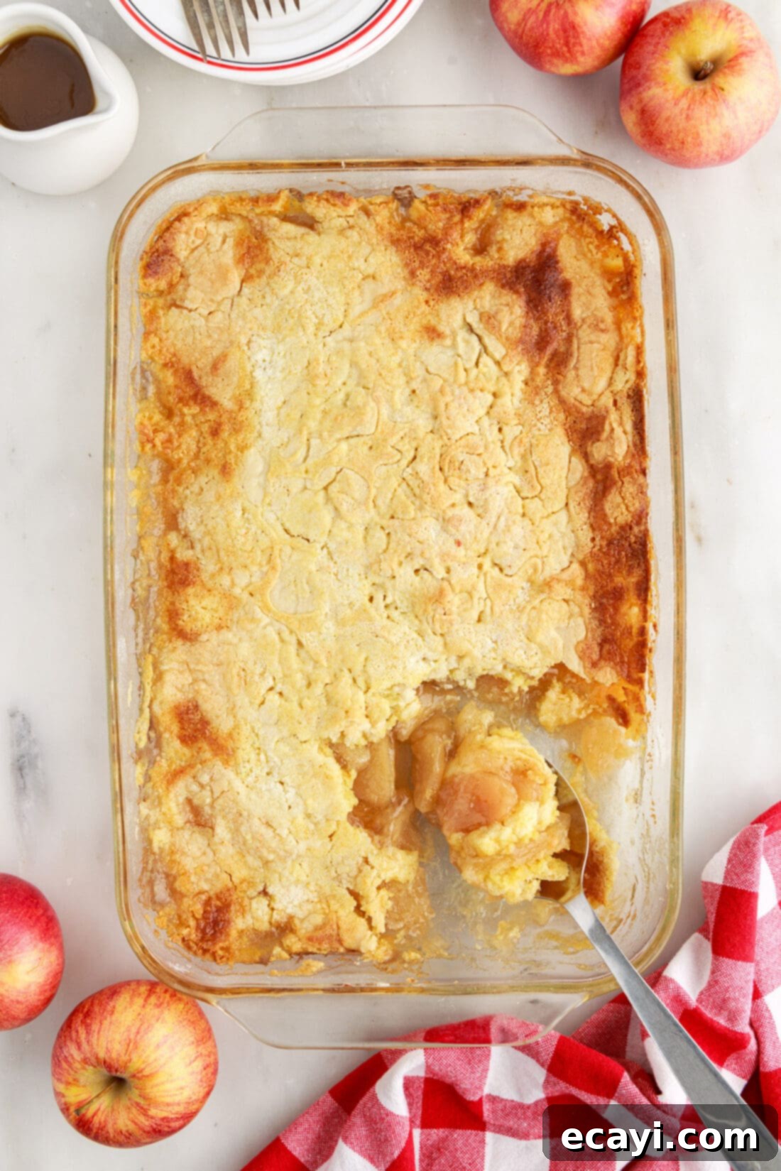 Golden Apple Streusel Bake 9 A pan of Apple Dump Cake with a serving spoon inside, showing the moist apple filling and crumbly cake topping.