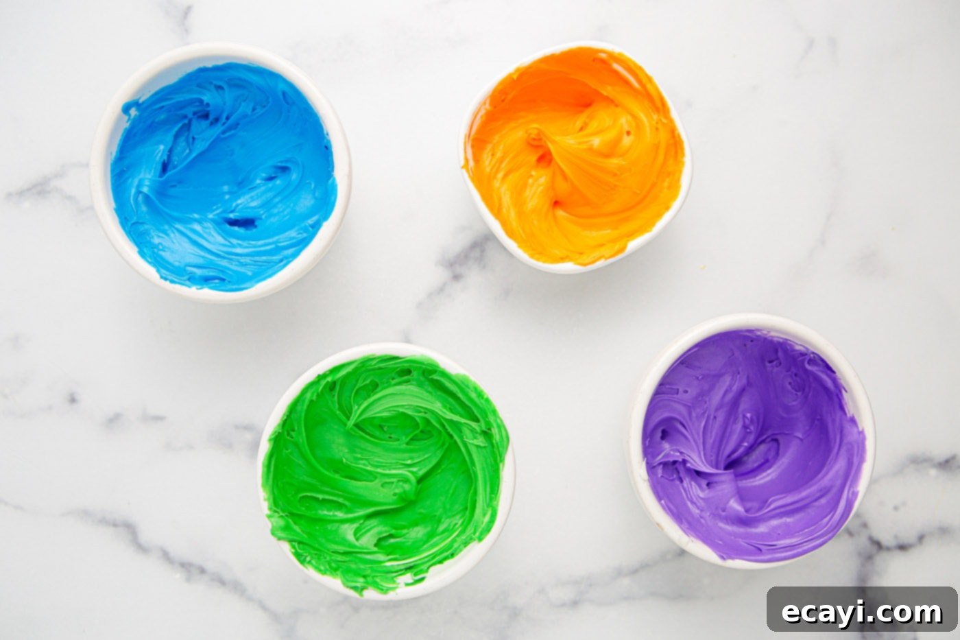 Ghoul-icious Cupcakes 8 Four bowls of frosting in Halloween colors: blue, purple, green, and orange