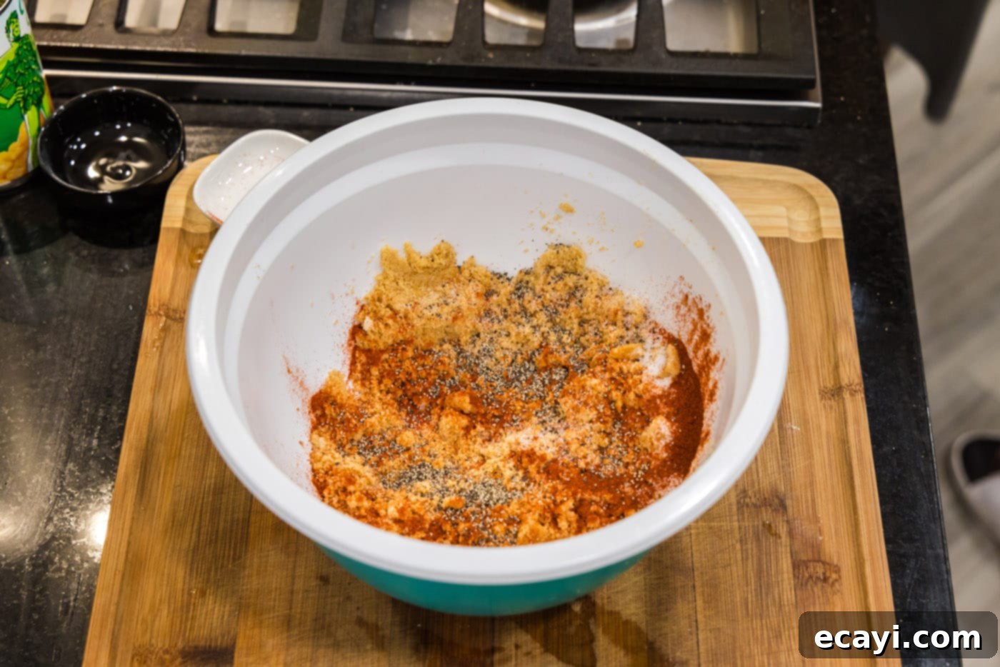 Creamy Baked Corn 13 Paprika, salt, and black pepper being mixed into the reserved buttery Ritz cracker crumbs in a small bowl