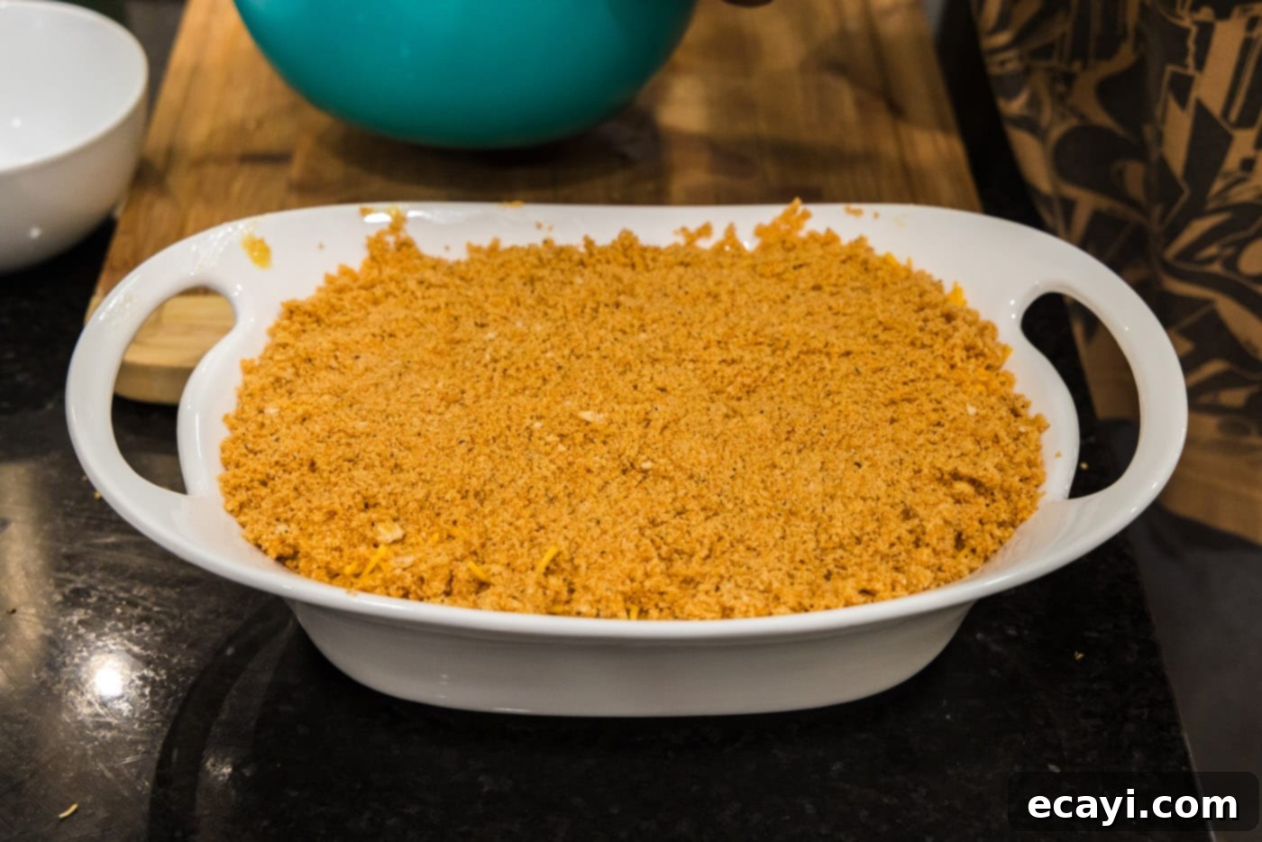 Creamy Baked Corn 14 The fully assembled scalloped corn casserole in a baking dish, topped with seasoned Ritz crackers and cheese, ready for the oven