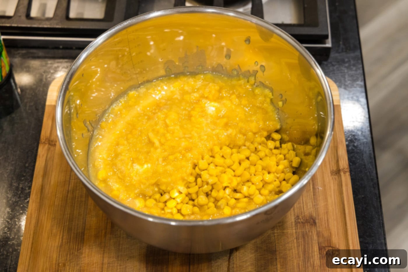 Creamy Baked Corn 8 Two types of canned corn, whole kernel and creamed, being mixed in a large bowl