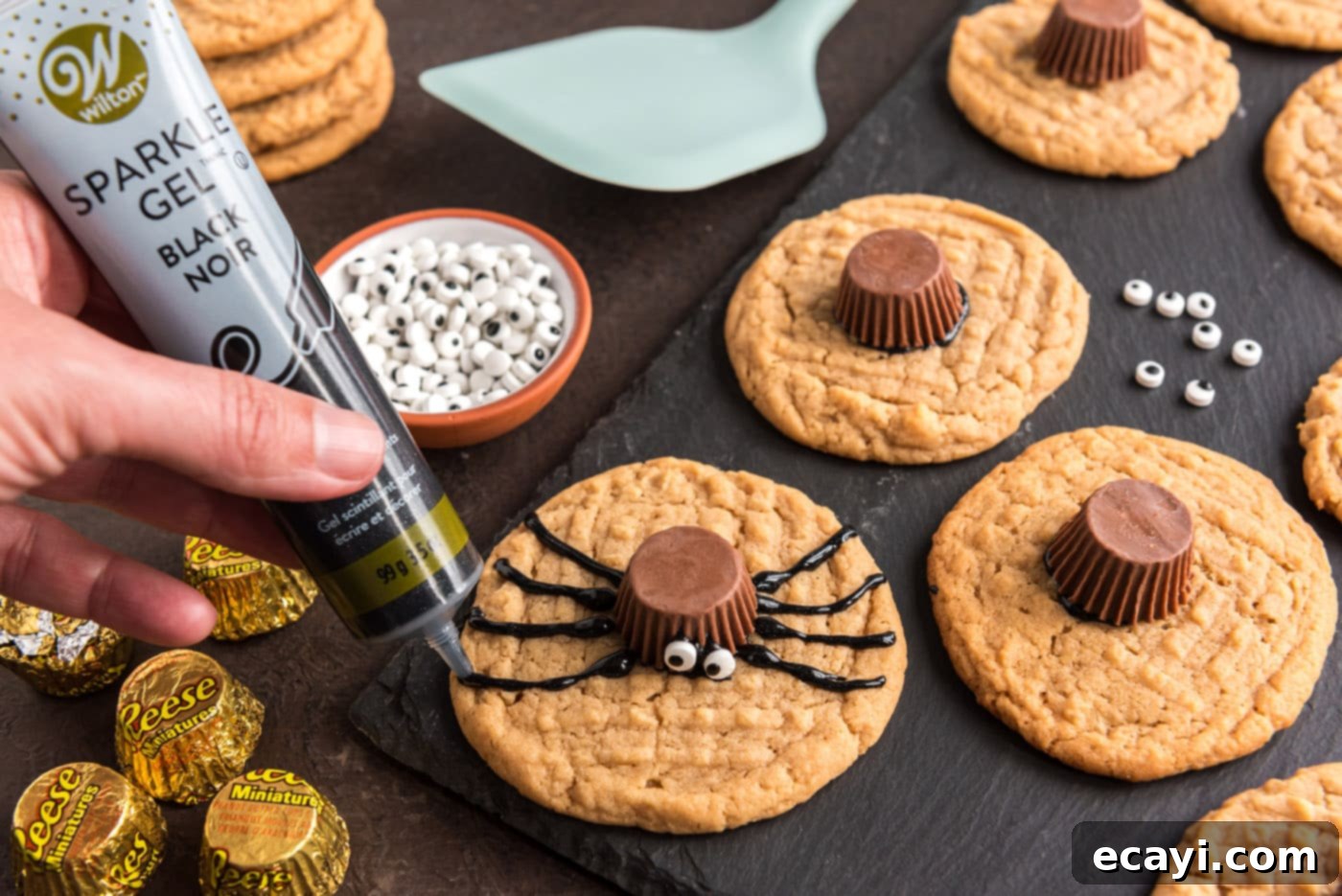 Spooky Spider Cookies 15 piping black decorator gel onto cookie to make spider legs