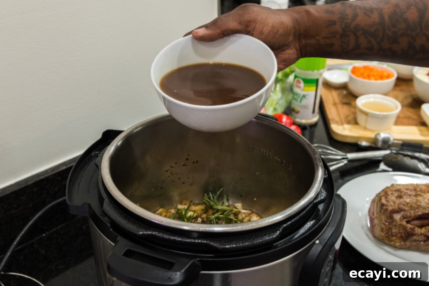 Effortless Instant Pot Roast Beef 11 pouring beef broth into instant pot with onion mixture