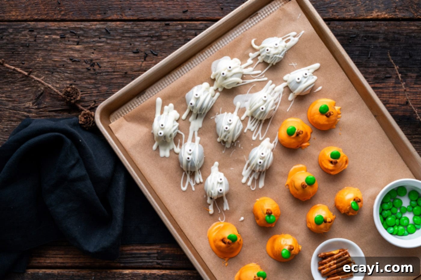 Wicked Oreo Wonders 9 Pumpkin Oreo truffles on a baking tray with mummy truffles, displaying finished designs