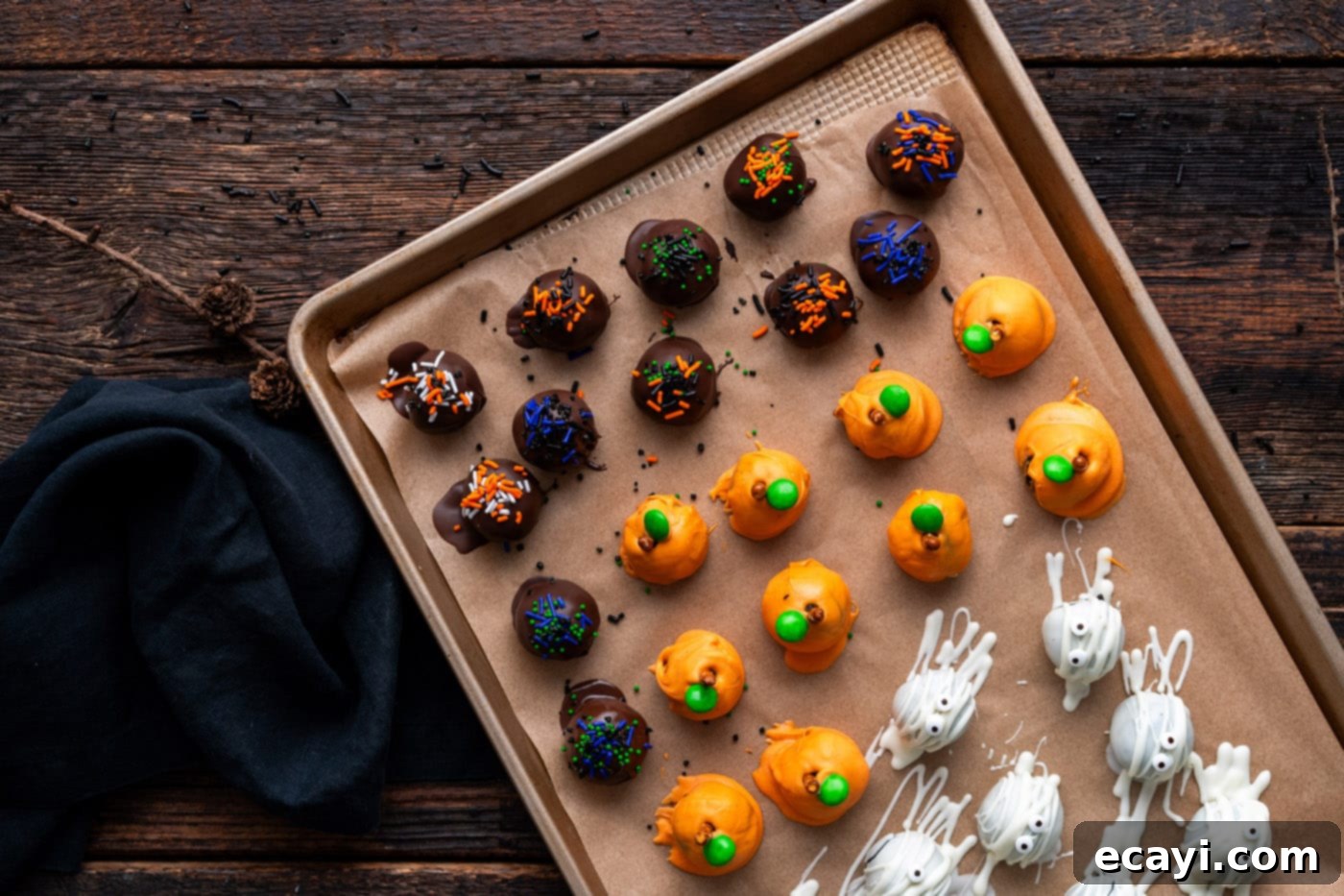 Wicked Oreo Wonders 11 Halloween Oreo truffles on a baking sheet, covered in assorted sprinkles