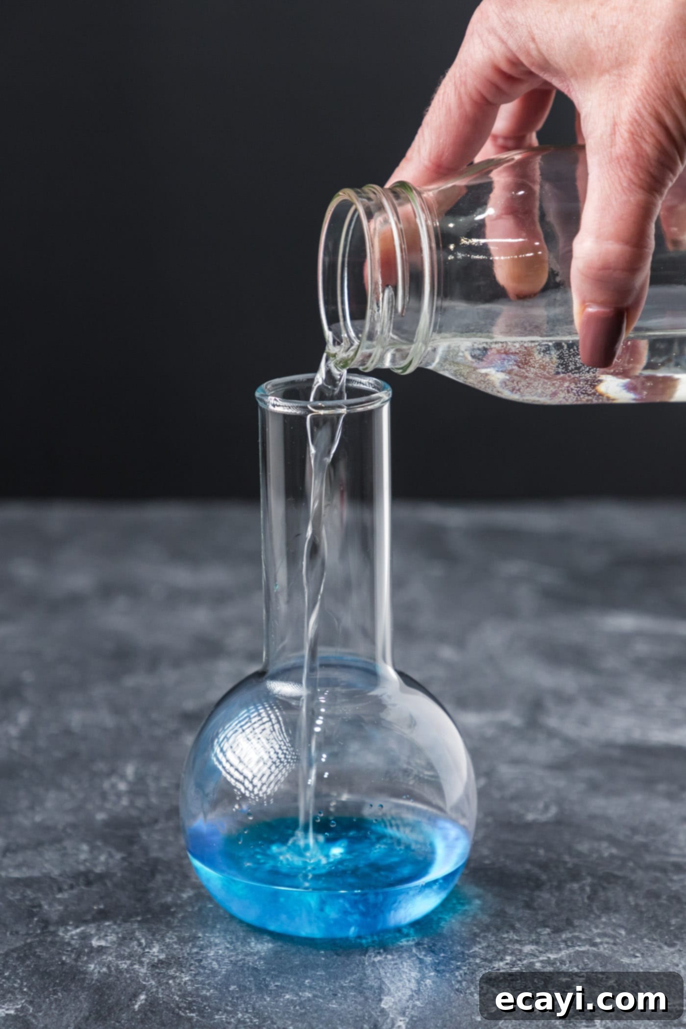 Amethyst Abyss Elixir 6 adding lemon lime soda to cocktail glass with blue curacao and coconut rum