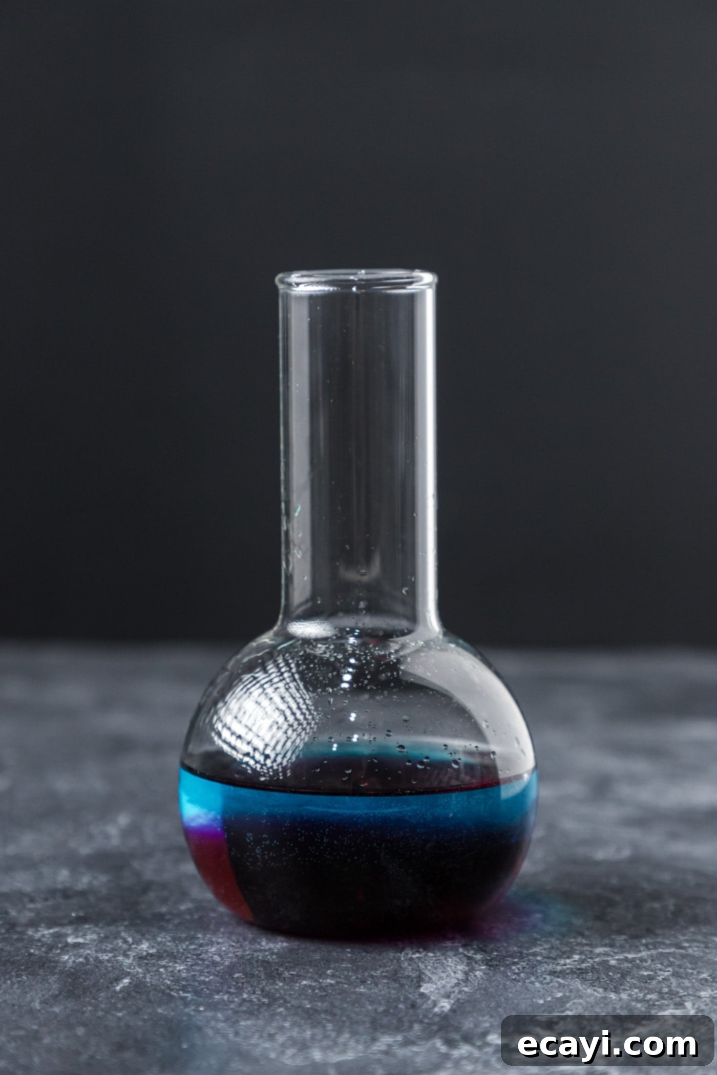Amethyst Abyss Elixir 8 purple people eater cocktail in a beaker glass