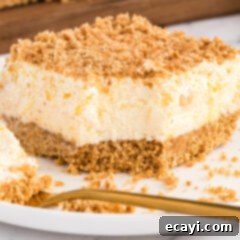 Pineapple Cloud Delight 12 A slice of Pineapple Dream Dessert with a single bite taken out, revealing its inviting layers and perfect for a sweet treat.