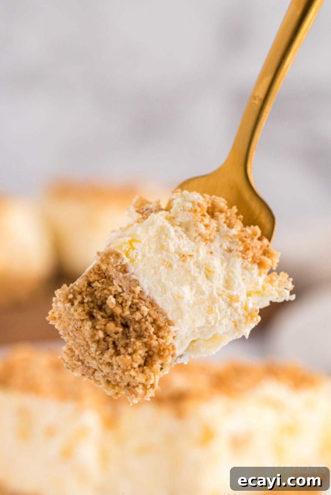 Pineapple dream is one of those perfect potluck desserts. Cream cheese, pineapple, whipped cream and graham crackers, yum! A fork taking a generous scoop of the layered Pineapple Dream Dessert, highlighting the fluffy whipped cream, creamy cheese layer, and crumbly base.
