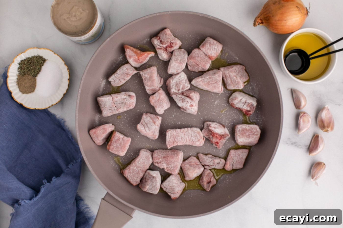 Homestyle Beef Noodles 6 flour coated beef cubes searing in a hot skillet, creating a crust