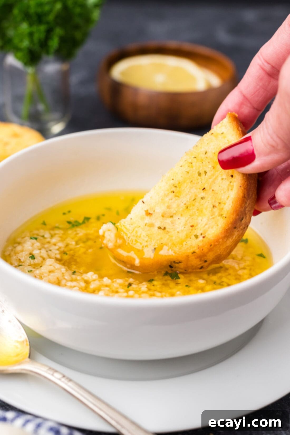 Liquid Gold Garlic Butter 2 Piece of bread being dipped into a bowl of golden Garlic Butter Sauce, highlighting its rich texture and inviting aroma.