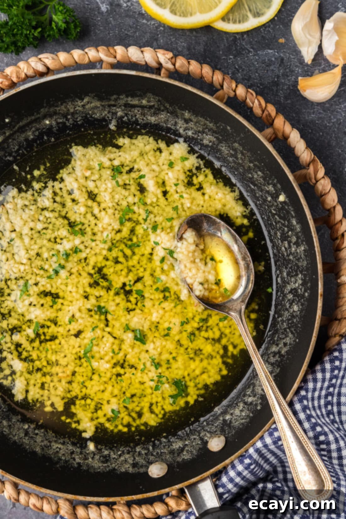 Liquid Gold Garlic Butter 3 A glistening skillet filled with golden Garlic Butter Sauce, a spoon resting within, ready to be served.