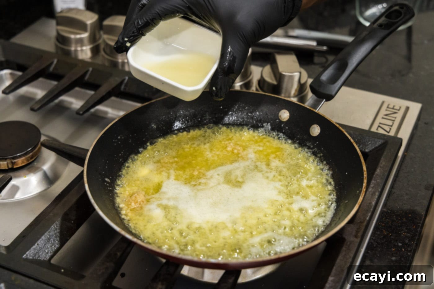 Liquid Gold Garlic Butter 7 Fresh lemon juice being poured into the skillet containing melted butter and sautéed garlic.