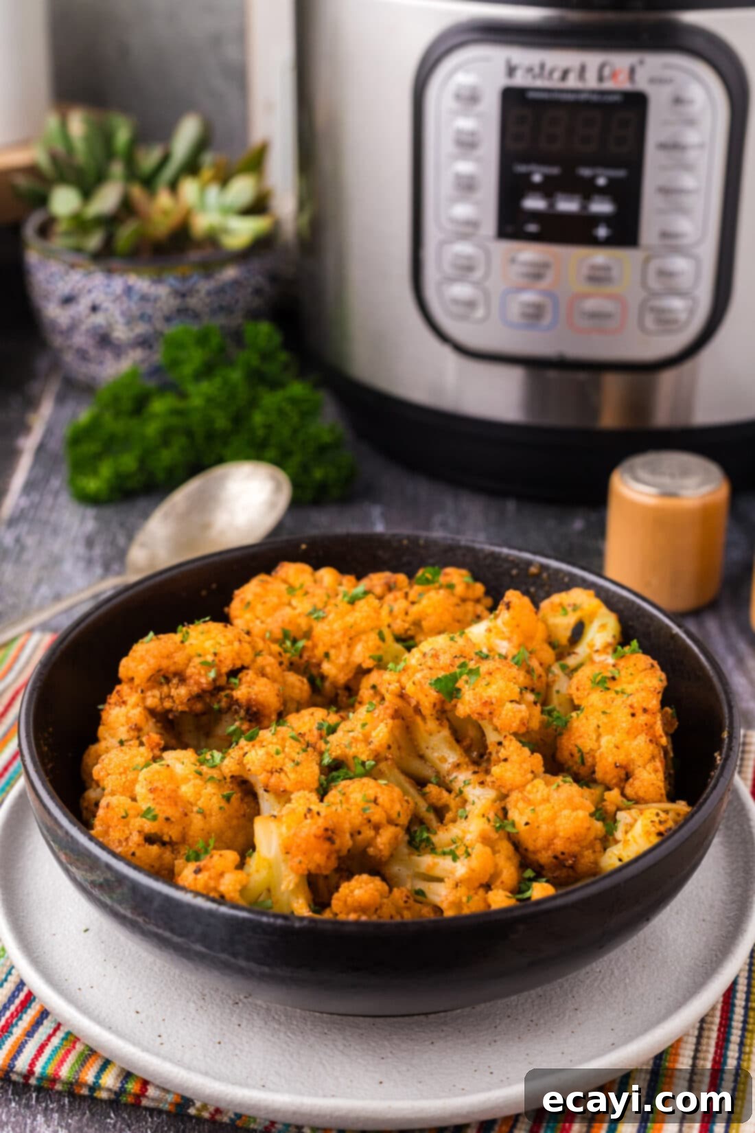 Effortless Instant Pot Cauliflower 2 Bowl of Instant Pot Cauliflower with an Instant Pot in the background