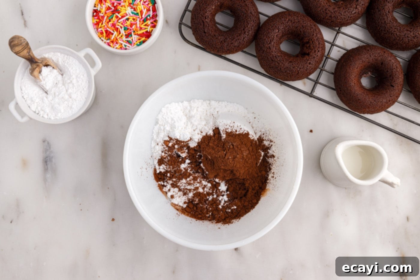 ChocoRings 14 cocoa powder and powdered sugar in a bowl, with milk being added to create a glaze