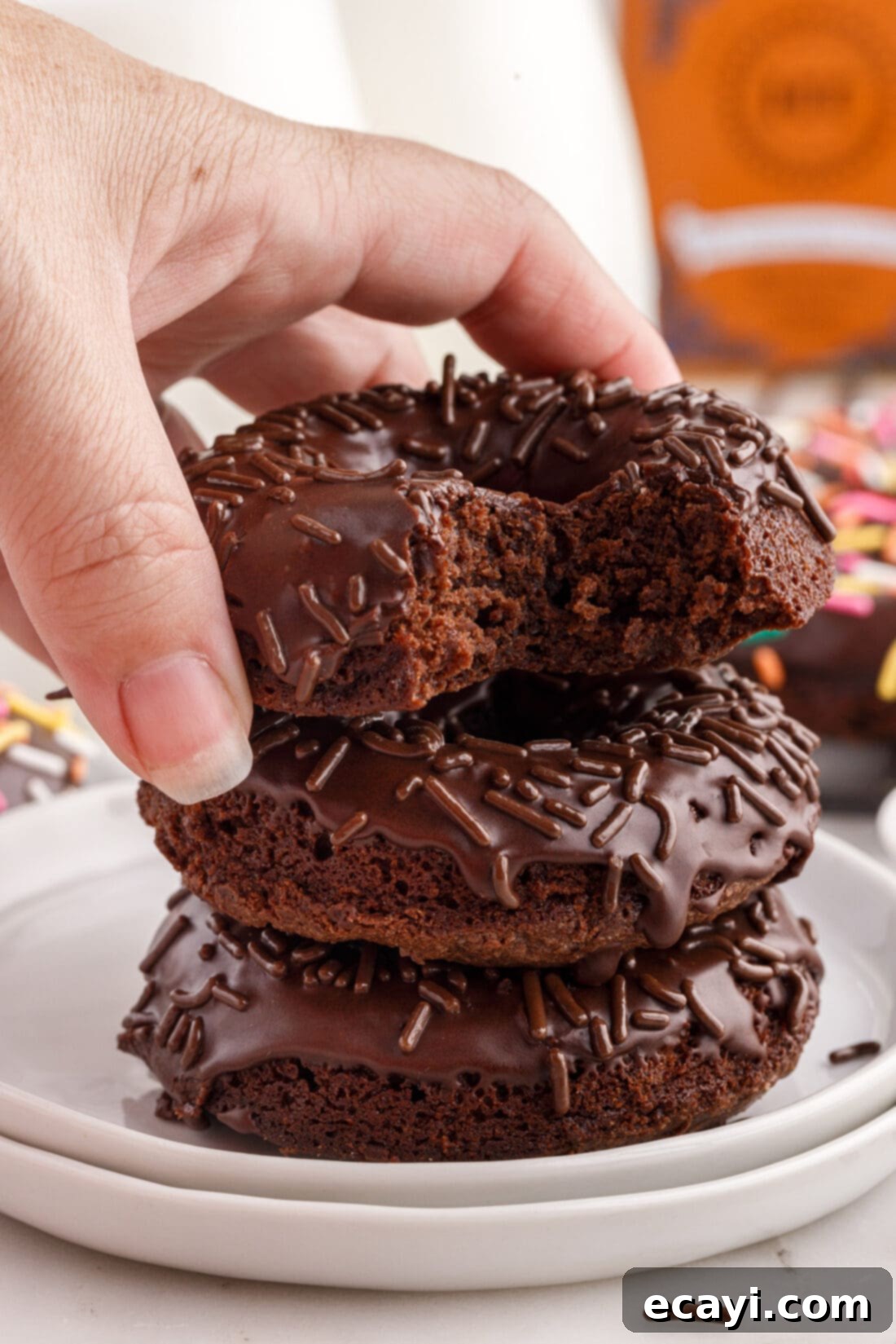 ChocoRings 18 Hand carefully placing a freshly glazed Bronut with sprinkles onto a growing stack of delicious bronuts