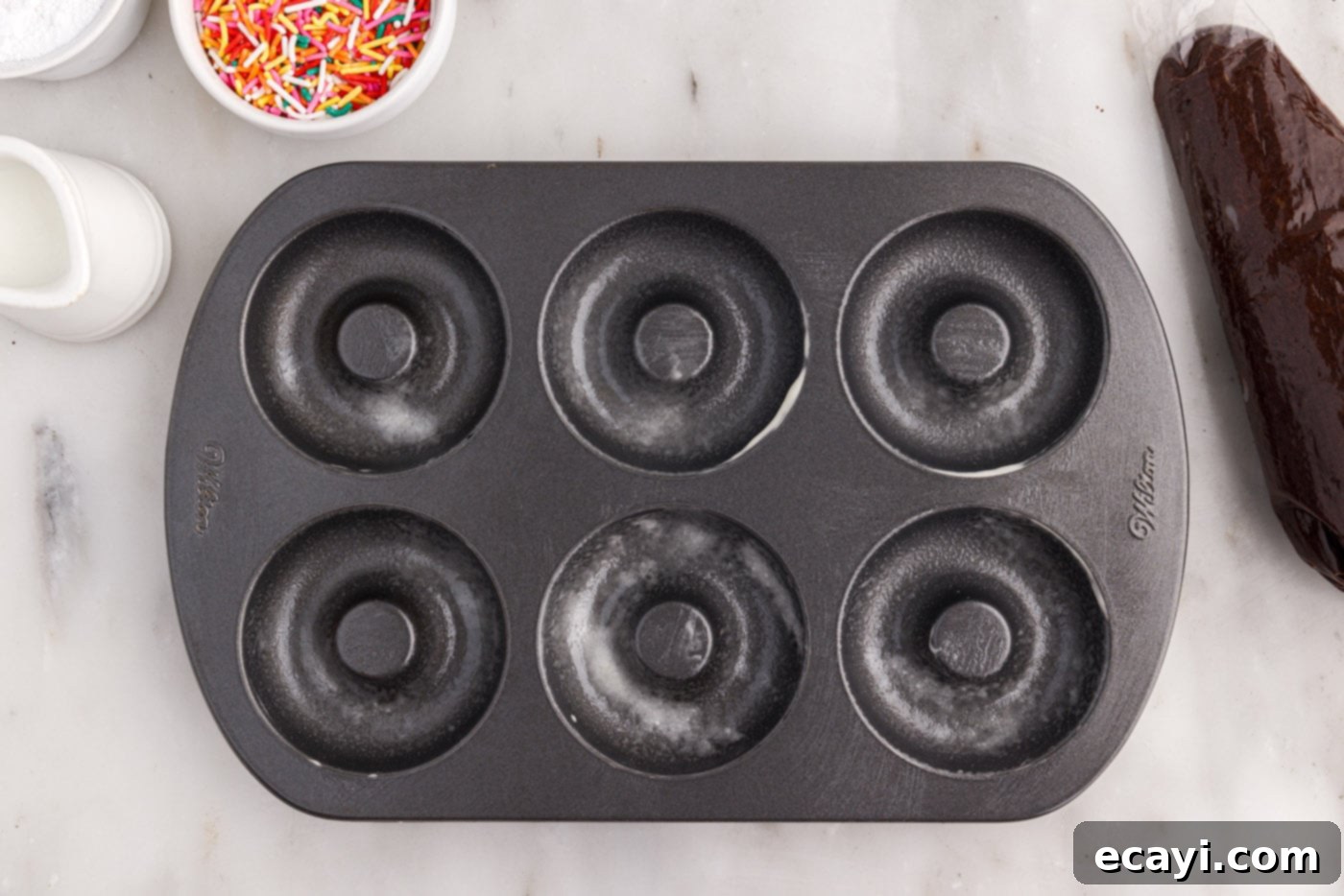 ChocoRings 10 baking pan sprayed with cooking spray with flour, ready for bronut batter