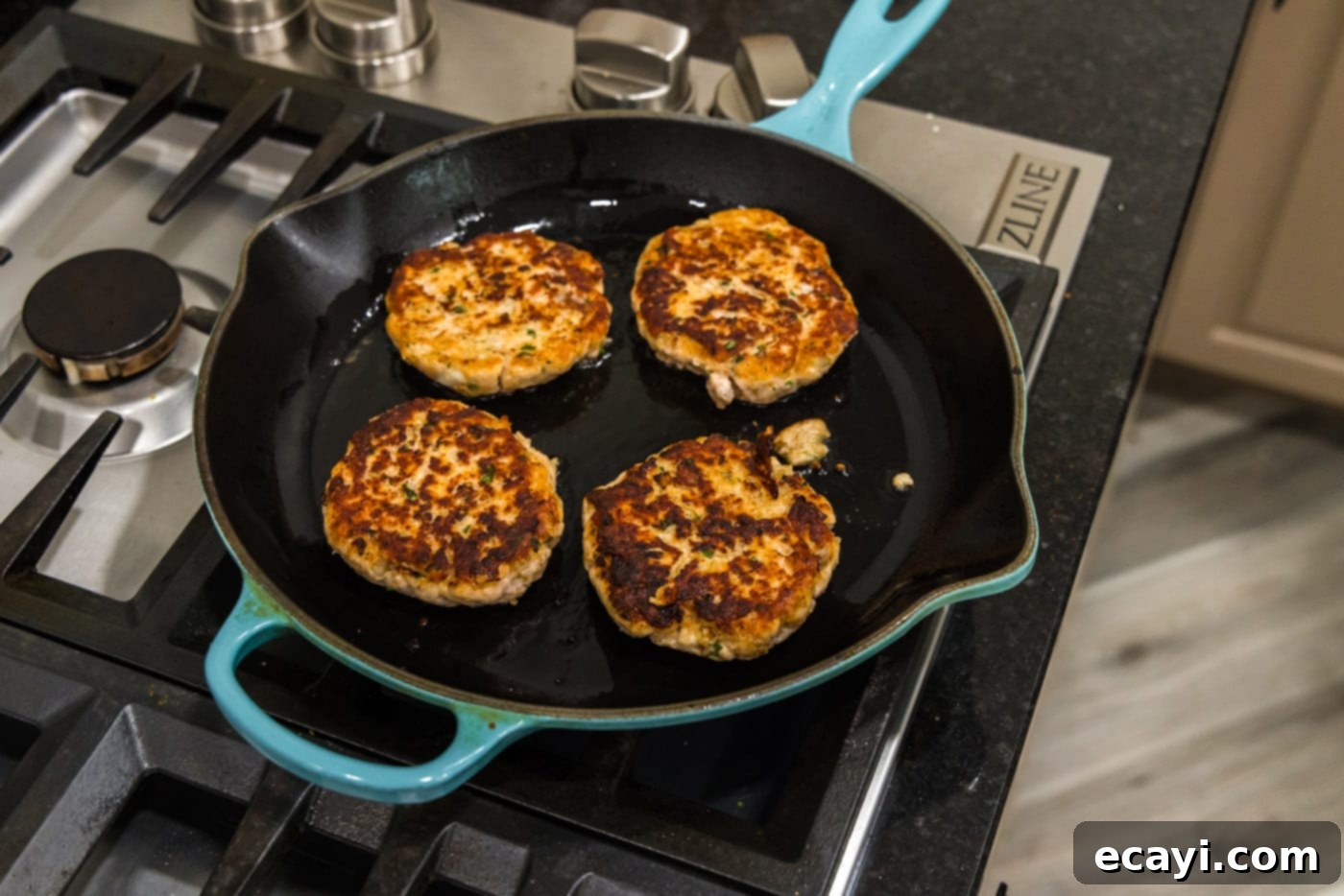 Delicious Salmon Burgers 12 Cooked salmon burgers with a golden crust in a skillet