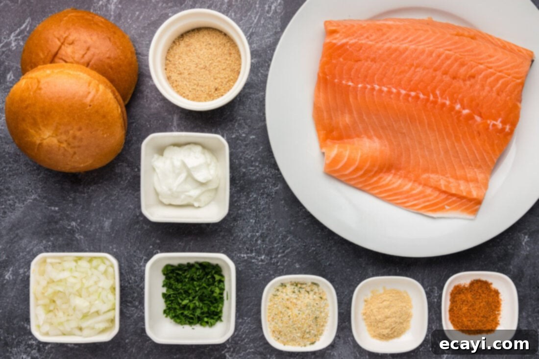 Delicious Salmon Burgers 4 A collection of fresh ingredients laid out for making salmon burgers, including salmon fillets, fresh parsley, onion, Greek yogurt, and spices