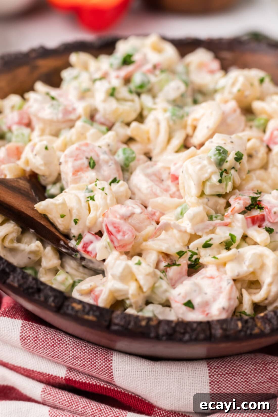 Lemon-Herb Shrimp Pasta Salad 11 A close-up shot of a single serving bowl of Shrimp Pasta Salad, garnished with a sprig of fresh parsley.