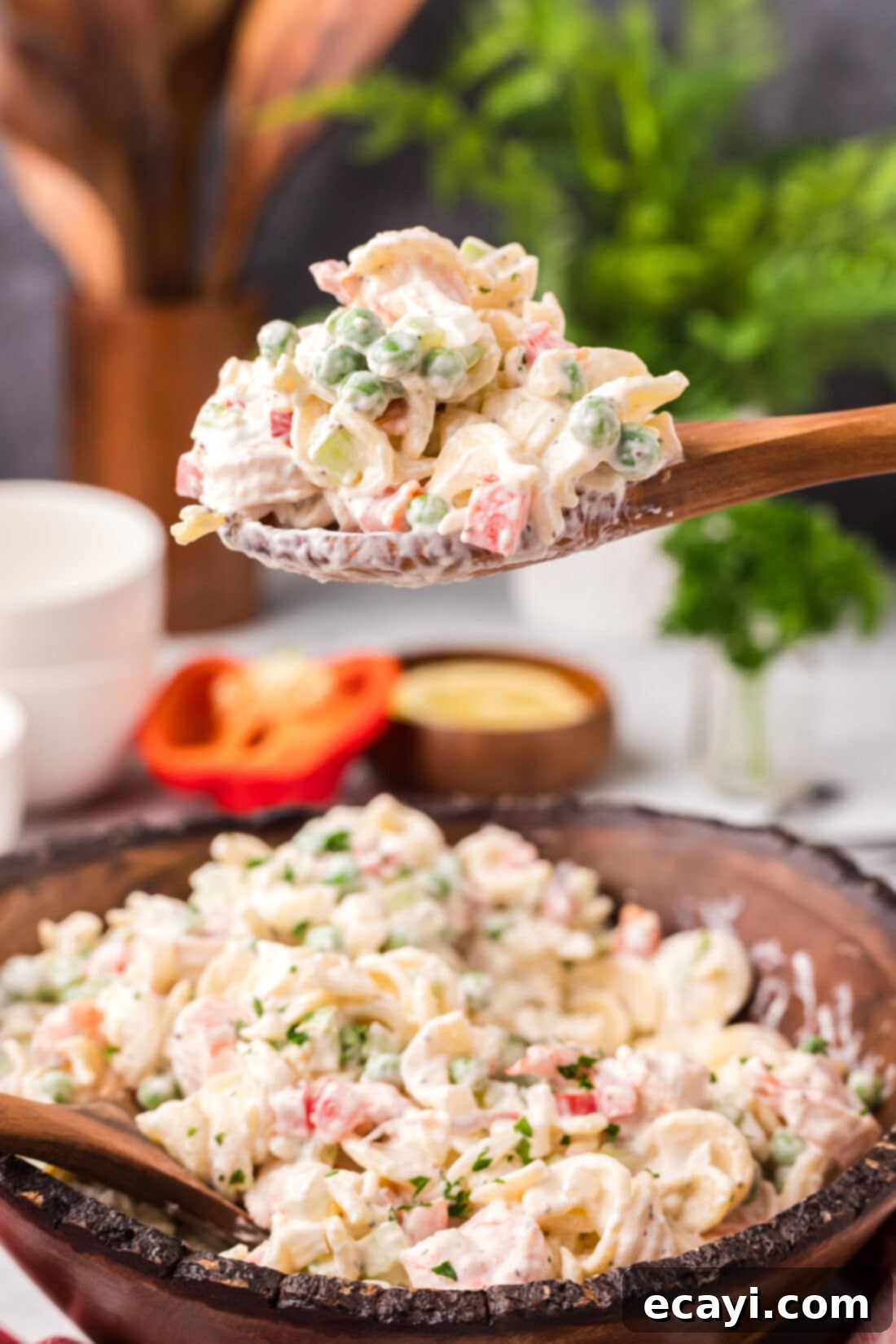 Lemon-Herb Shrimp Pasta Salad 3 A serving spoon lifting a generous portion of Shrimp Pasta Salad, showcasing the plump shrimp and colorful vegetables.