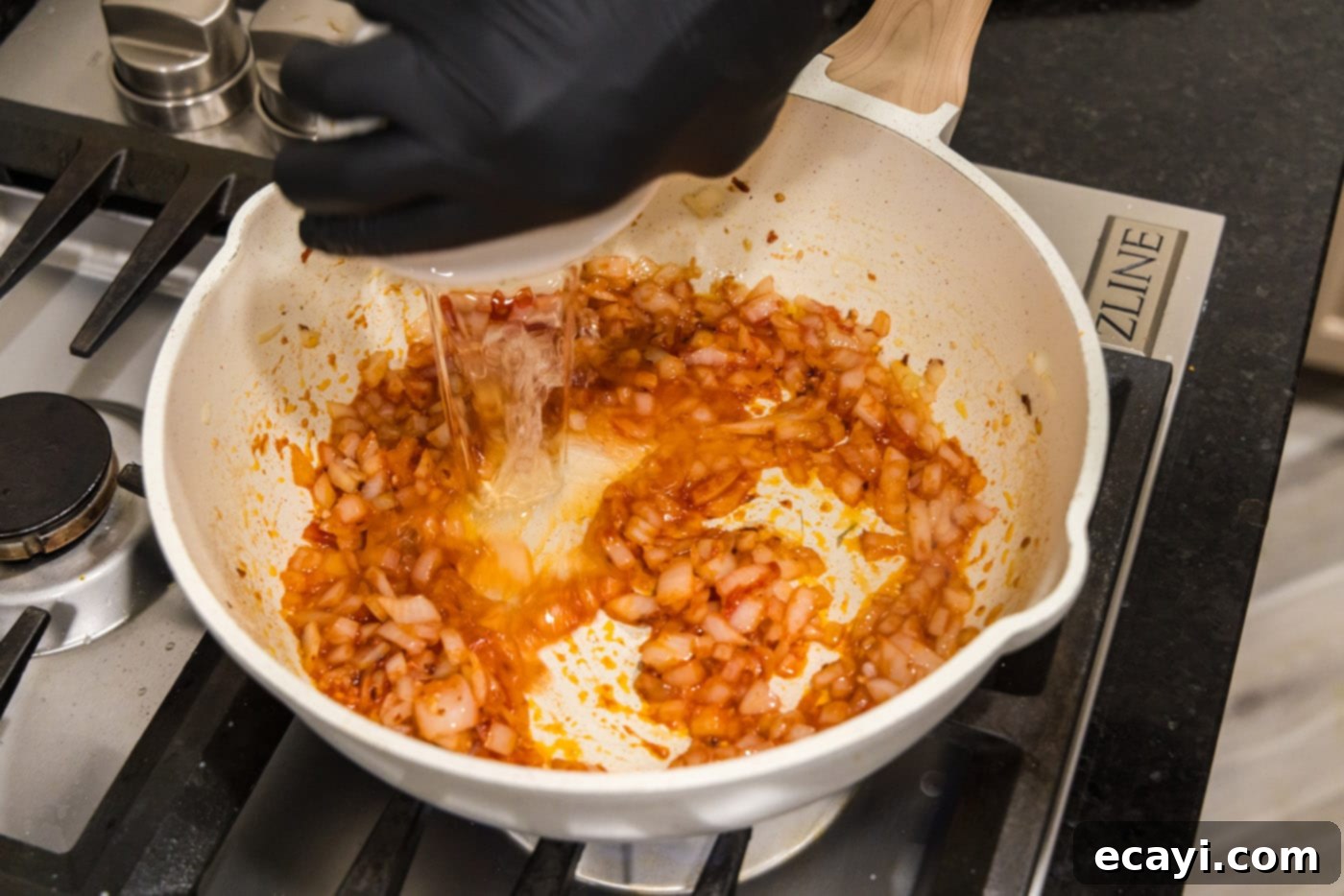 Creamy Vodka Pasta Sauce 7 pouring vodka into the simmering tomato sauce mixture