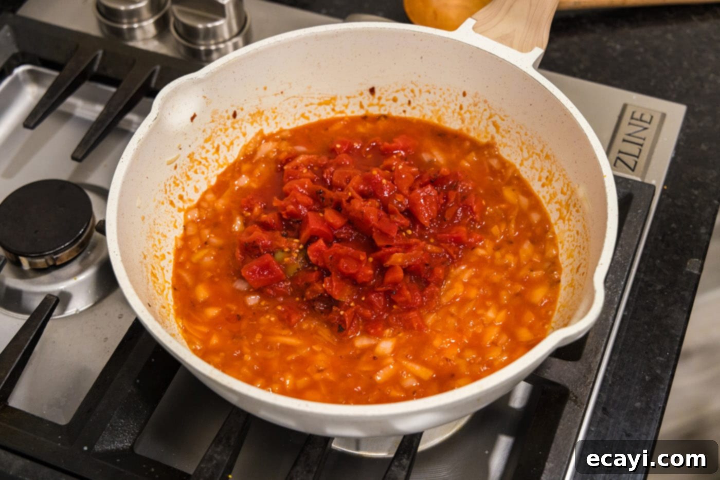 Creamy Vodka Pasta Sauce 8 adding crushed tomatoes to the skillet with vodka and onion mixture