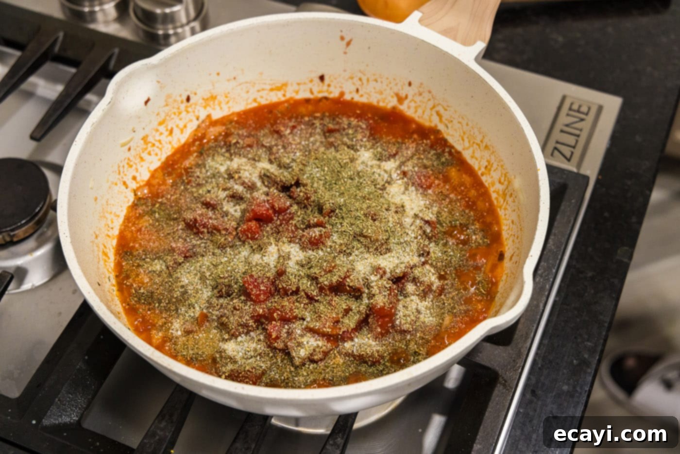 Creamy Vodka Pasta Sauce 9 seasonings being added to the skillet with parmesan cheese and vodka sauce
