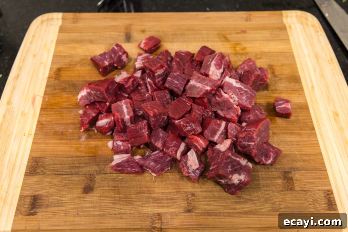 Delicious Instant Pot Beef and Broccoli 5 Expertly cubed flank steak pieces arranged neatly on a cutting board, prepped and ready for cooking.