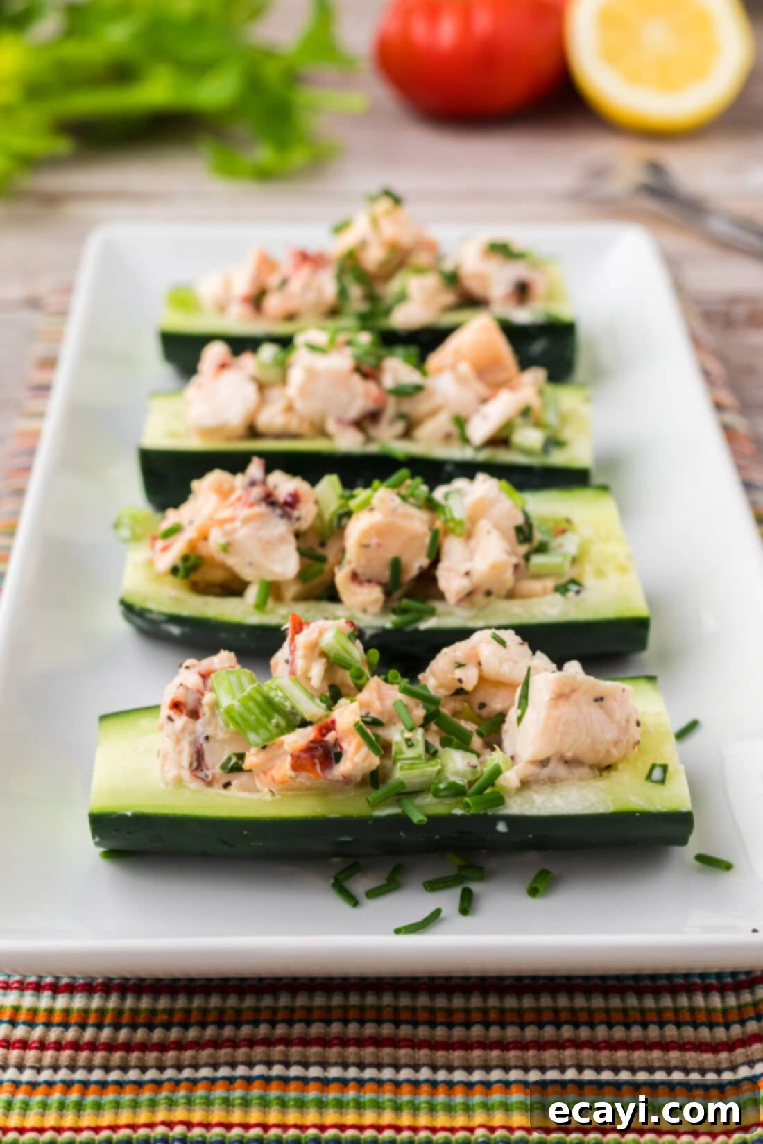 Chilled Lobster Cucumber Canoes 12 A beautifully composed image of four Lobster Cucumber Boats arranged artfully on a serving platter, highlighting their freshness and appetizing presentation.