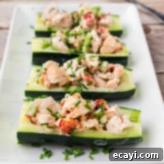 Chilled Lobster Cucumber Canoes 13 Four Lobster Cucumber Boats on a white serving platter topped with chives