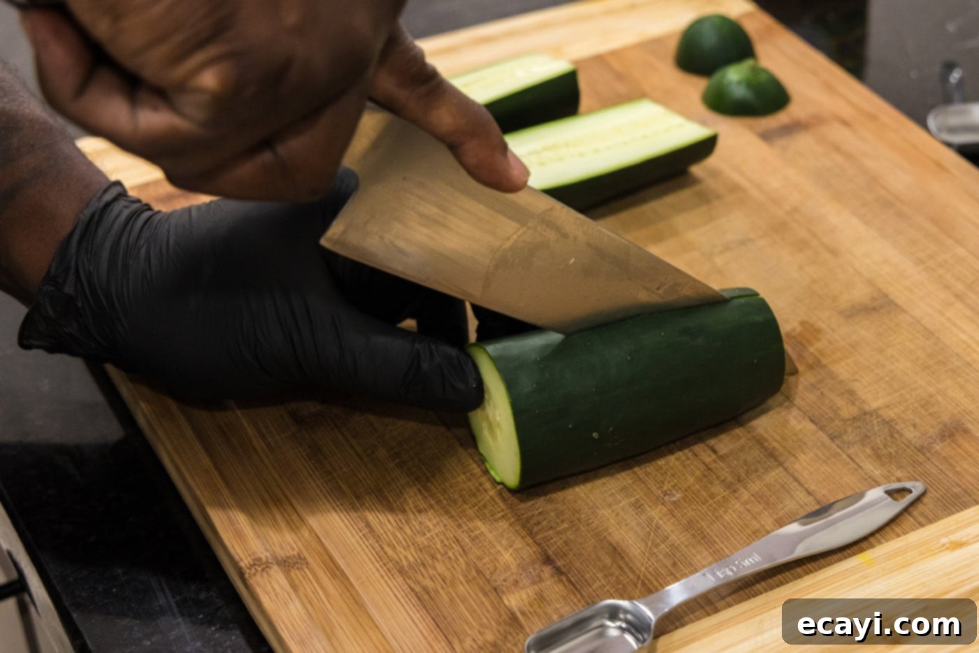 Chilled Lobster Cucumber Canoes 10 The process of slicing cucumber halves lengthwise with a knife, illustrating how to create the foundational long, scoopable shape for the edible boats.