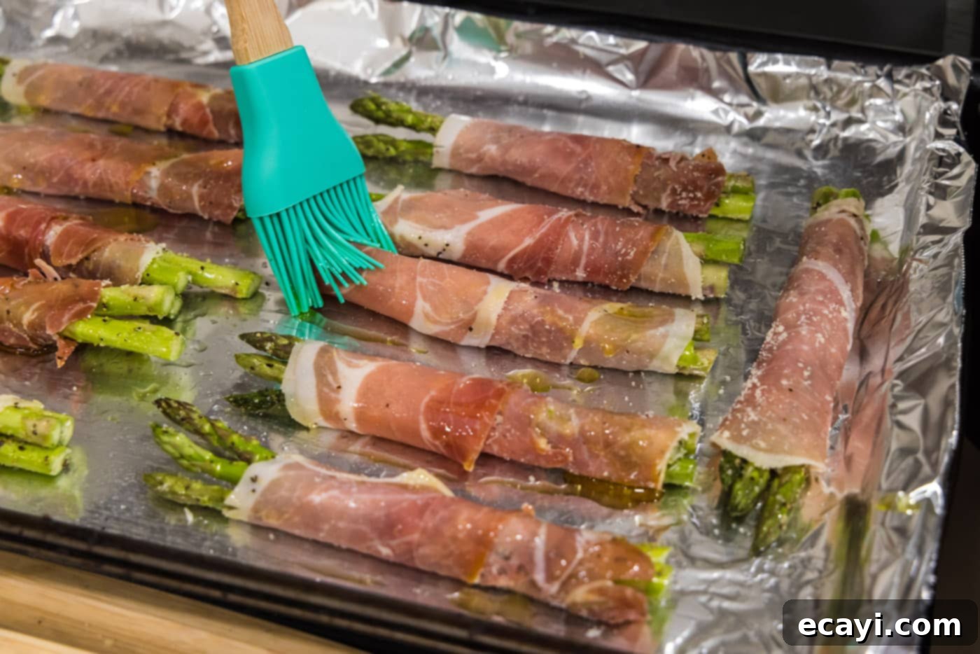 Crispy Prosciutto-Wrapped Asparagus 13 basting prosciutto asparagus with olive oil mixture