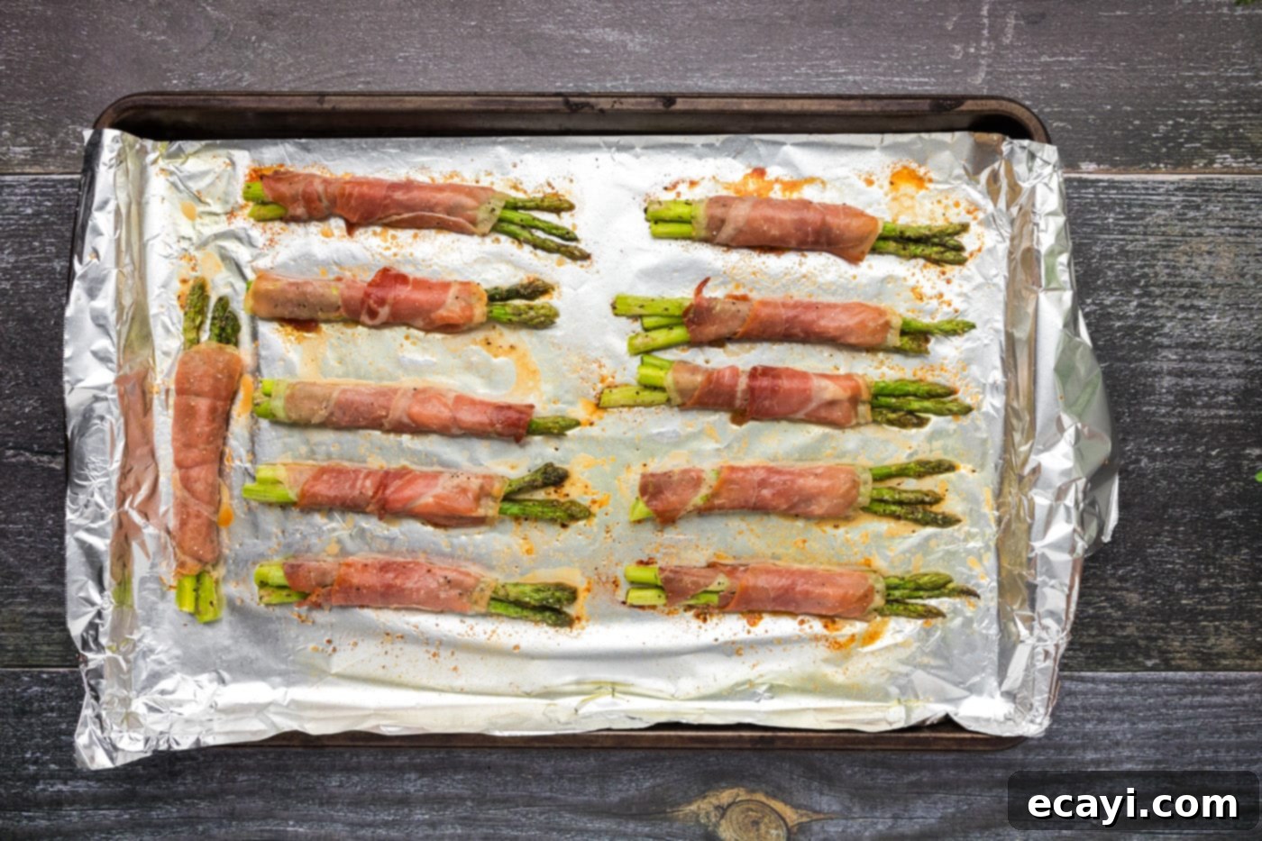 Crispy Prosciutto-Wrapped Asparagus 14 prosciutto wrapped asparagus on a baking sheet